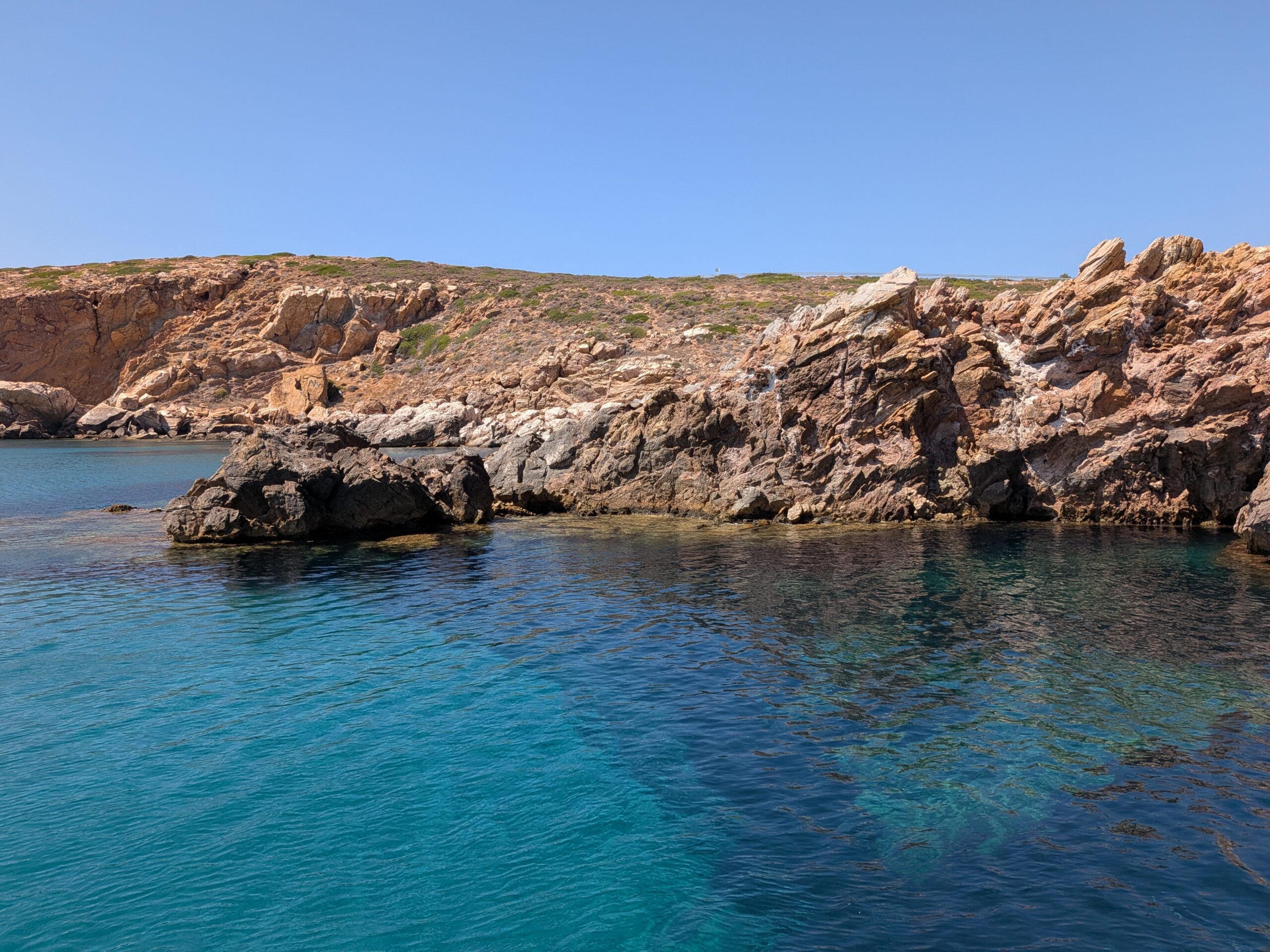 White beach beds and shallow turquoise water, small boats bobbing