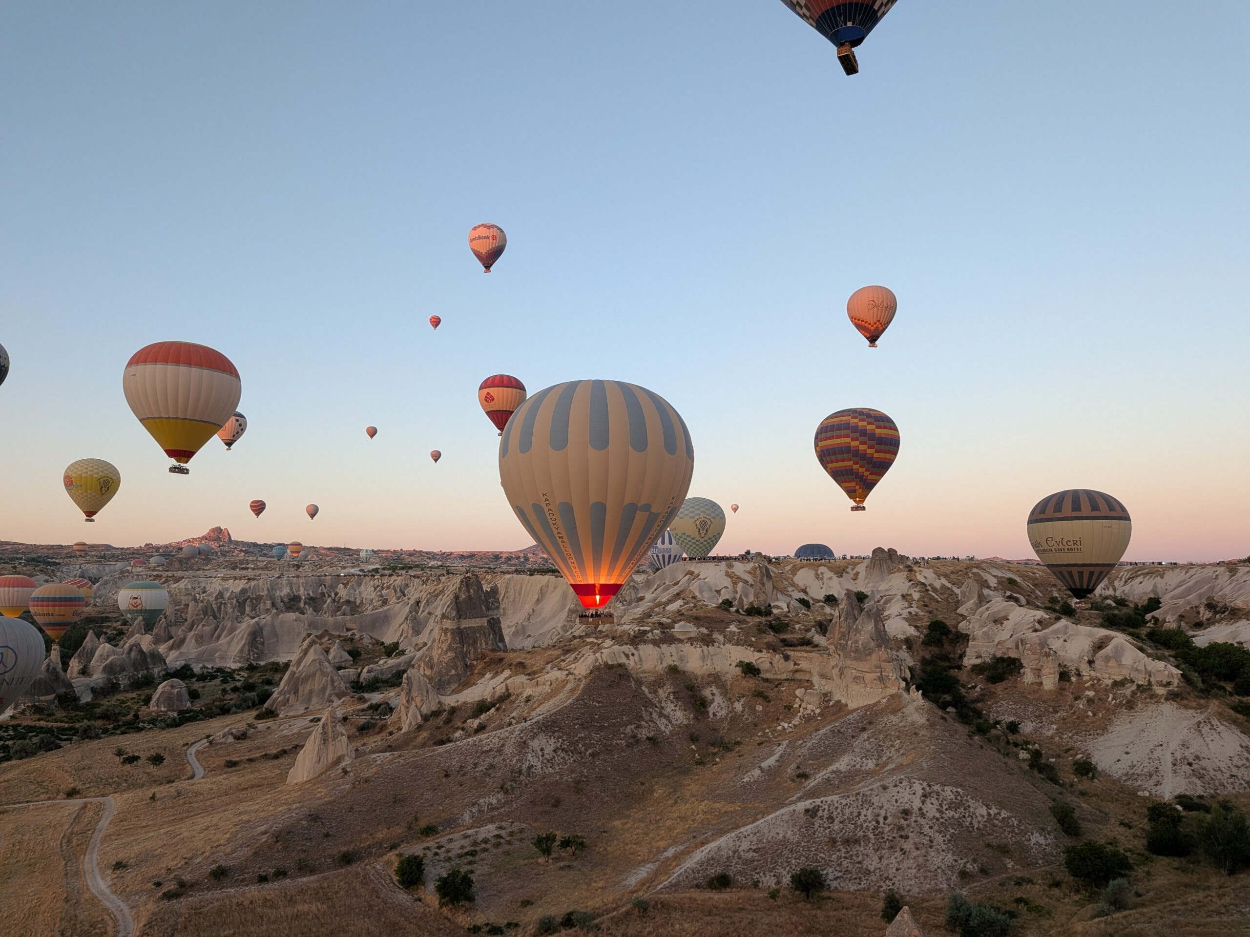 Hot-air balloons rising over Cappadocia at sunrise
